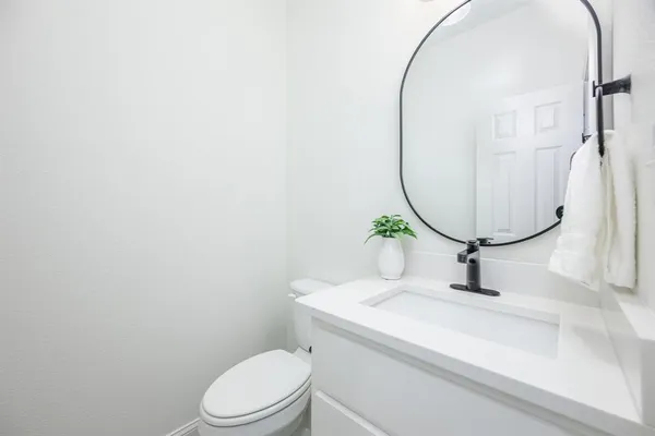 a bathroom with a sink a toilet and a mirror