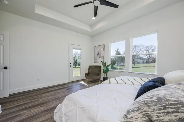 a bedroom with a bed wooden floor and window