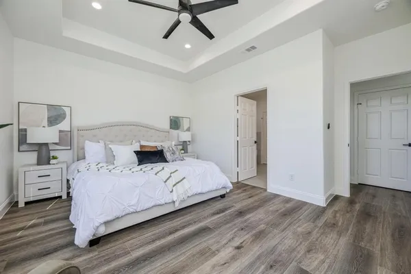 a bedroom with a bed and wooden floor