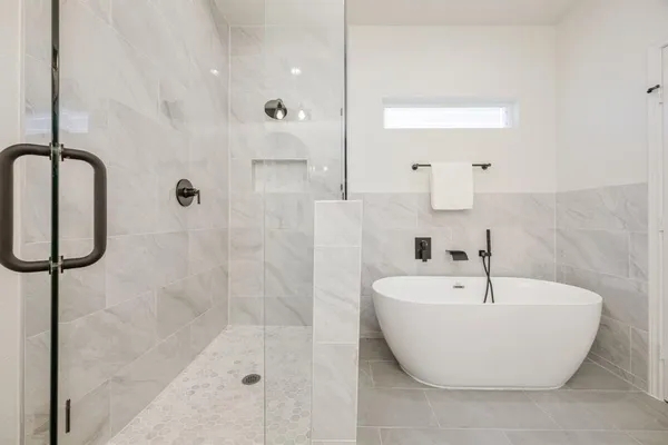a bathroom with a tub sink and mirror