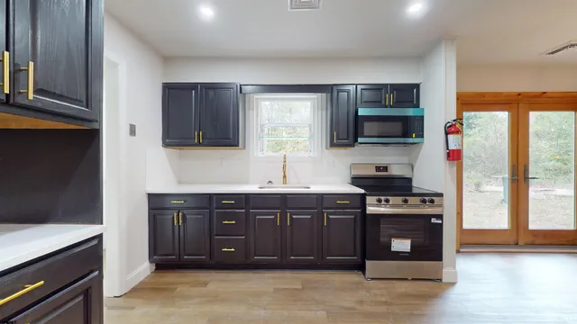 a kitchen with stainless steel appliances granite countertop a stove a sink and a microwave