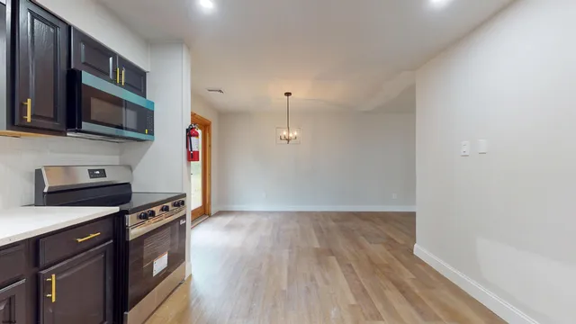 a kitchen with stainless steel appliances a stove a microwave and wooden floor