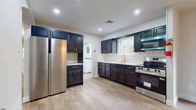 a kitchen with stainless steel appliances granite countertop a refrigerator stove and microwave