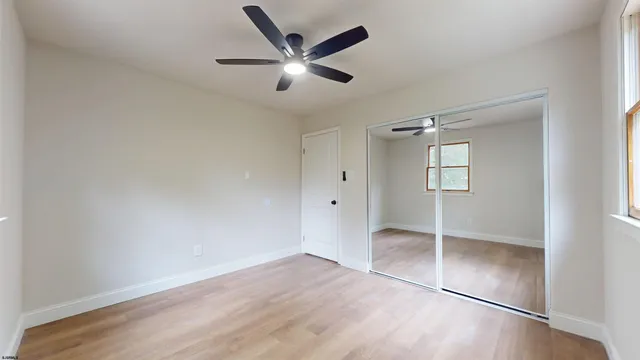 an empty room with closet and windows