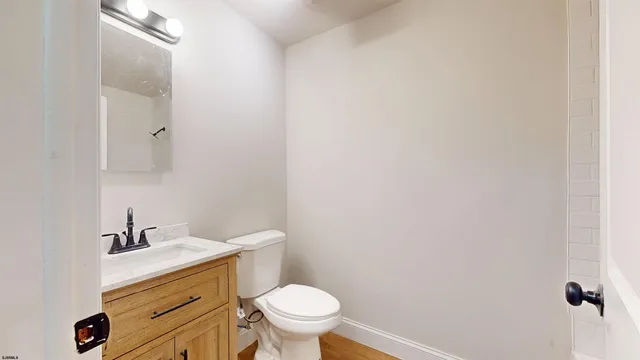 a bathroom with a granite countertop toilet and a sink