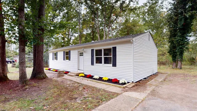 a backyard of a house with barbeque oven tree and wooden fence