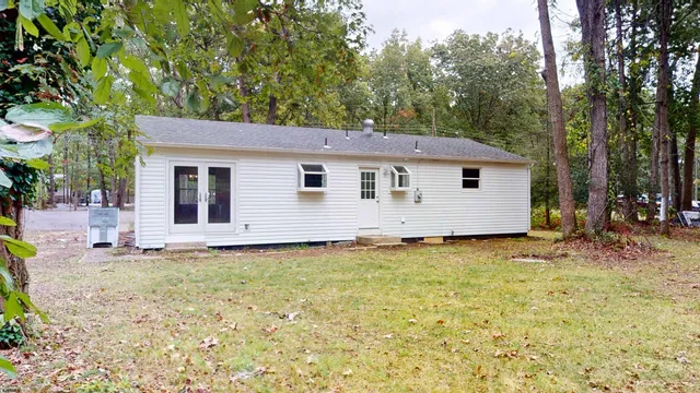 a backyard of a house with table and chairs