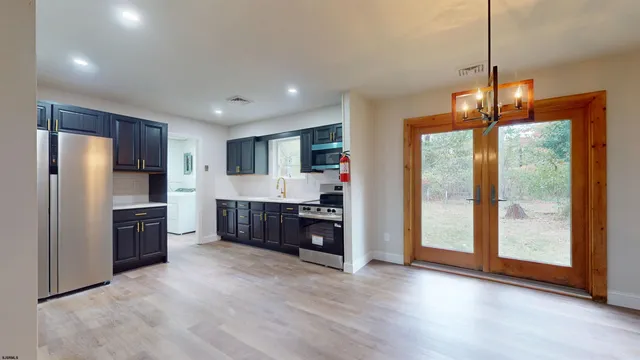 a large kitchen with a large window and stainless steel appliances