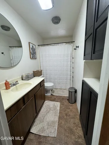 a bathroom with a double vanity sink toilet and shower