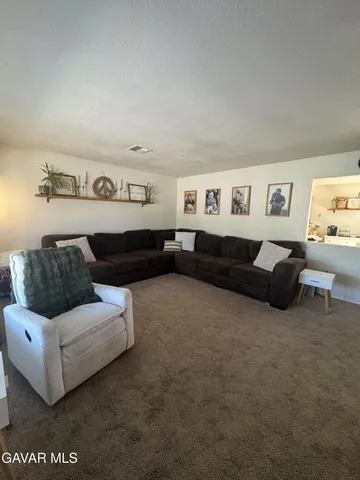 a living room with furniture and a wall painting