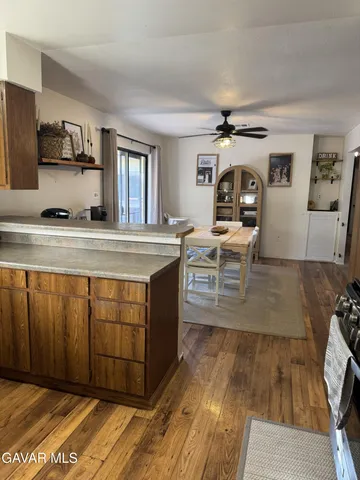 a view of a kitchen with kitchen island a stove a sink dishwasher and wooden cabinets