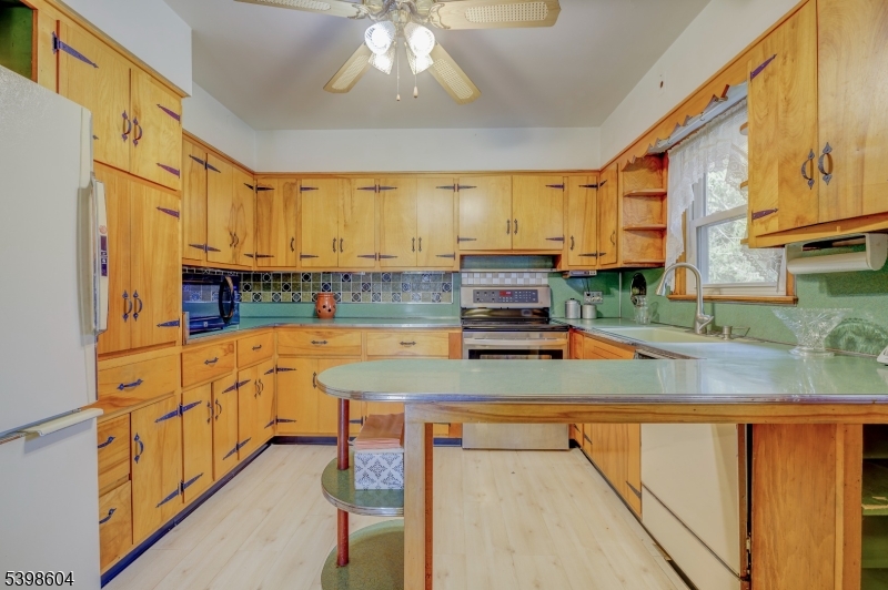 1621 Terrill Road Scotch Plains, NJ 07076 - Photo 15 of 48 a kitchen with stainless steel appliances a sink a stove top oven a counter space and cabinets