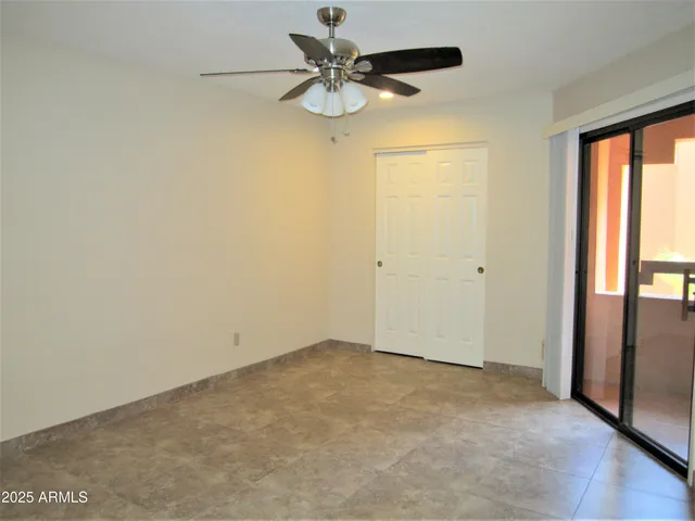 an empty room with a window and a fan