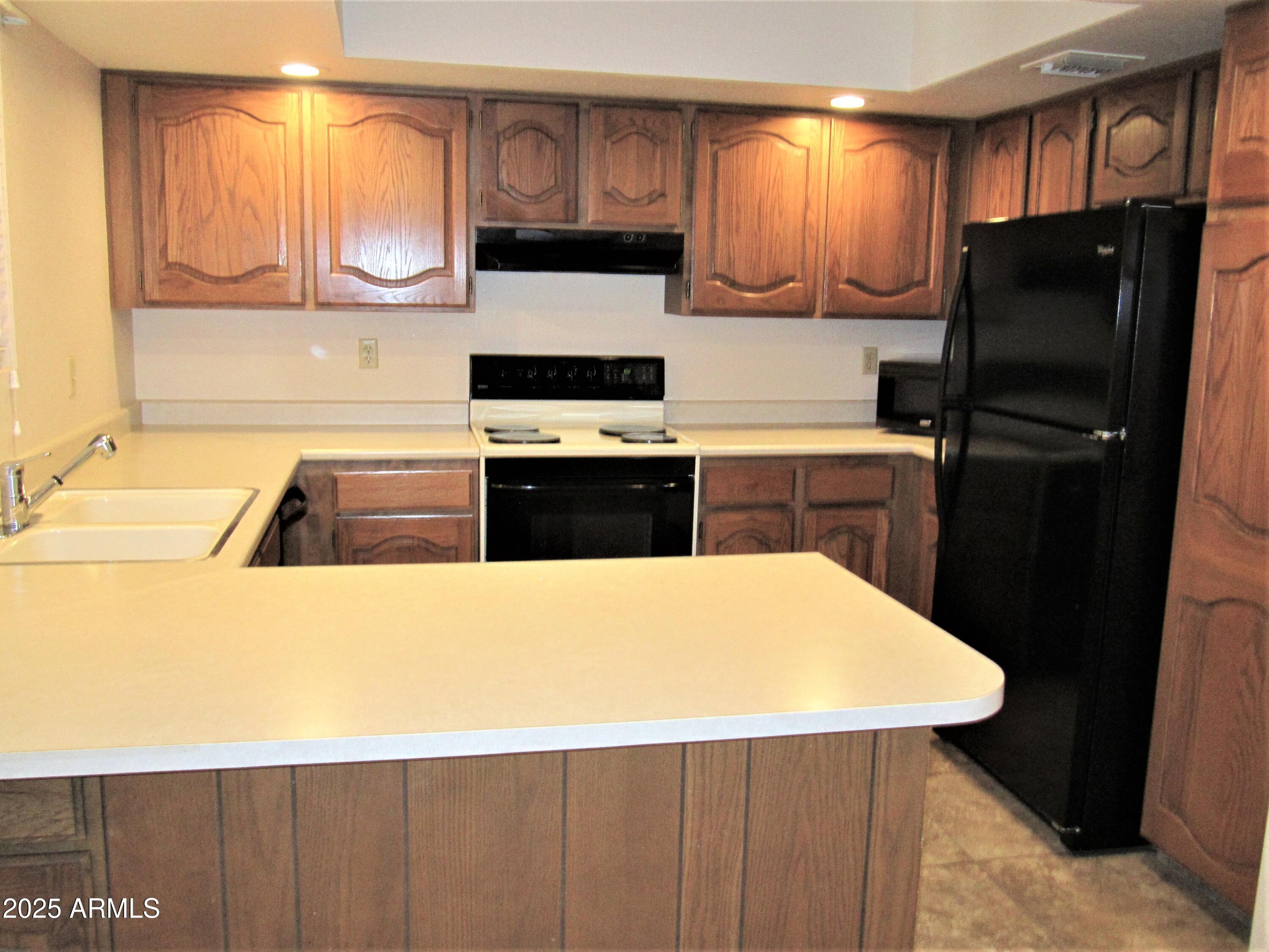 4303 East Cactus Road, Unit 310 Phoenix, AZ 85032 - Photo 5 of 27 a kitchen with a refrigerator and a sink