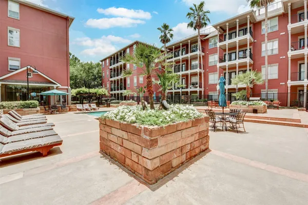 a view of a building with sitting area and garden