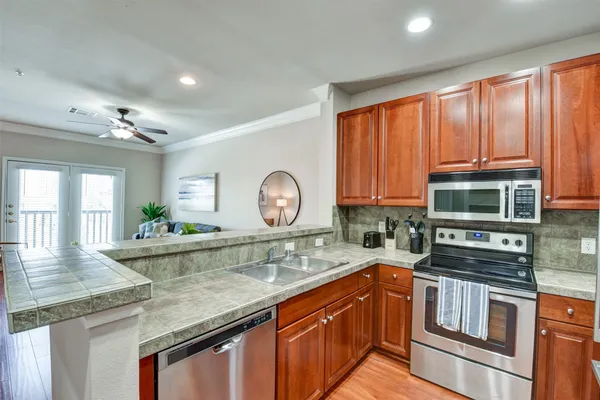a kitchen with stainless steel appliances granite countertop a stove a sink and a microwave