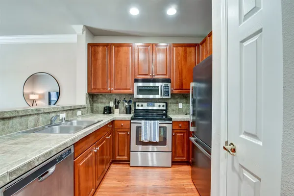 a kitchen with stainless steel appliances granite countertop a stove a sink and a refrigerator