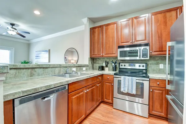 a kitchen with stainless steel appliances granite countertop a stove a sink and a microwave