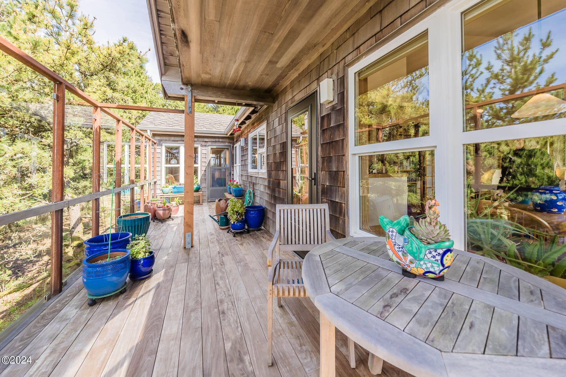6855 Nestucca Ridge Road Pacific City, OR 97135 - Photo 23 of 44 a view of a patio with couches chairs potted plants and wooden floor