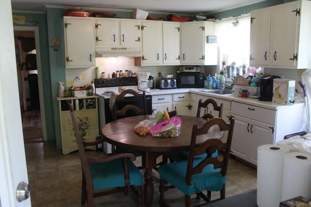 118 Eastern Avenue Gloucester, MA 01930 - Photo 24 of 40 a kitchen with granite countertop a table chairs stove and cabinets