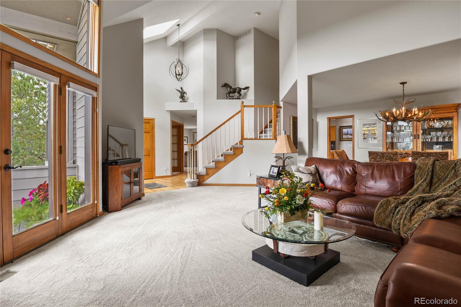 386 Monte Vista Road Golden, CO 80401 - Photo 11 of 32 a living room with furniture flowers and a chandelier