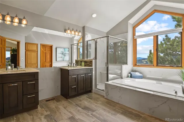 a bathroom with a tub a sink and a large mirror