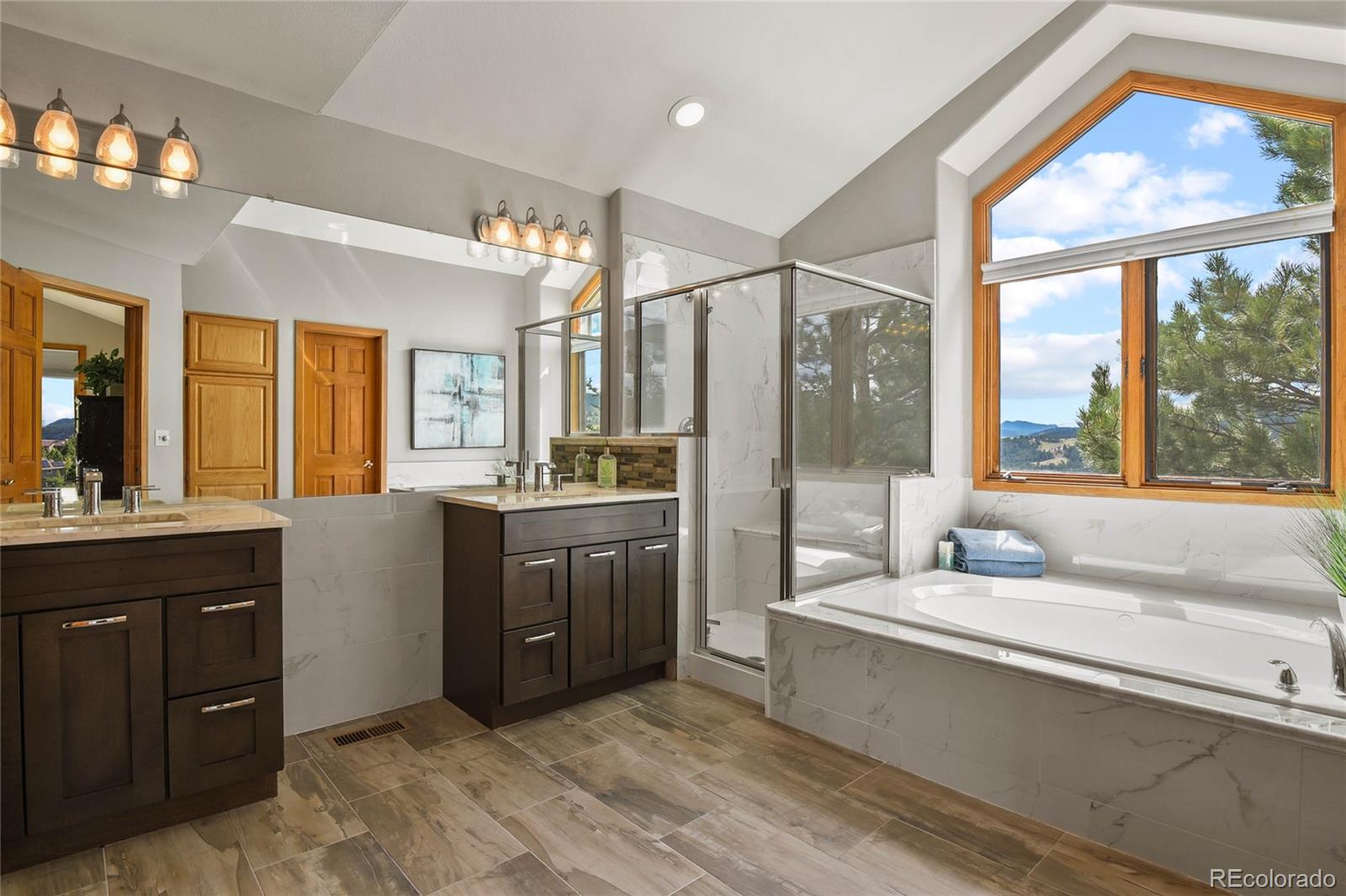 386 Monte Vista Road Golden, CO 80401 - Photo 21 of 32 a bathroom with a tub a sink and a large mirror