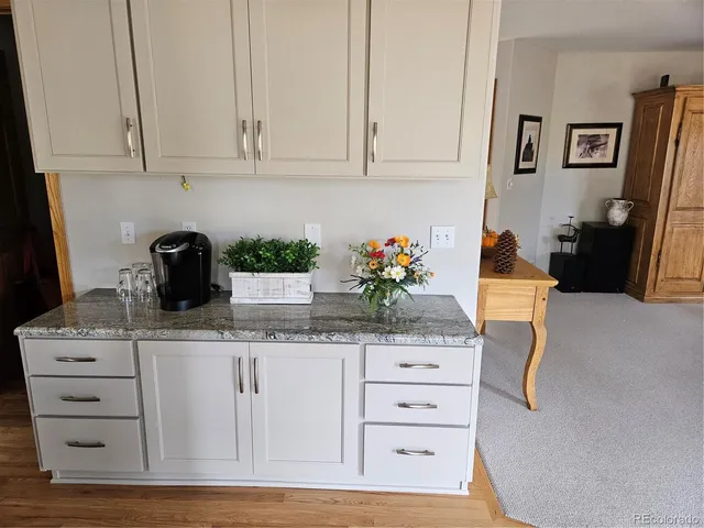 a kitchen with granite countertop white cabinets and black appliances