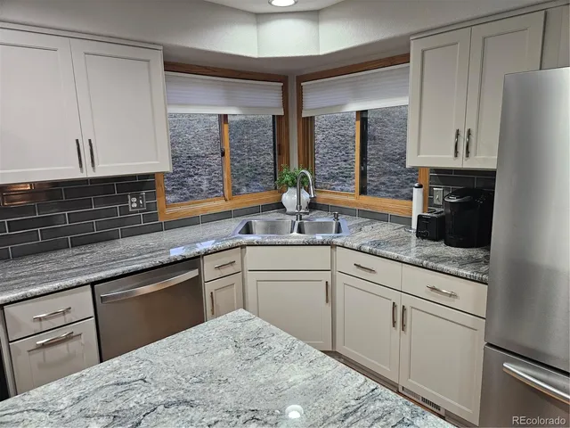 a kitchen with stainless steel appliances granite countertop a sink and cabinets