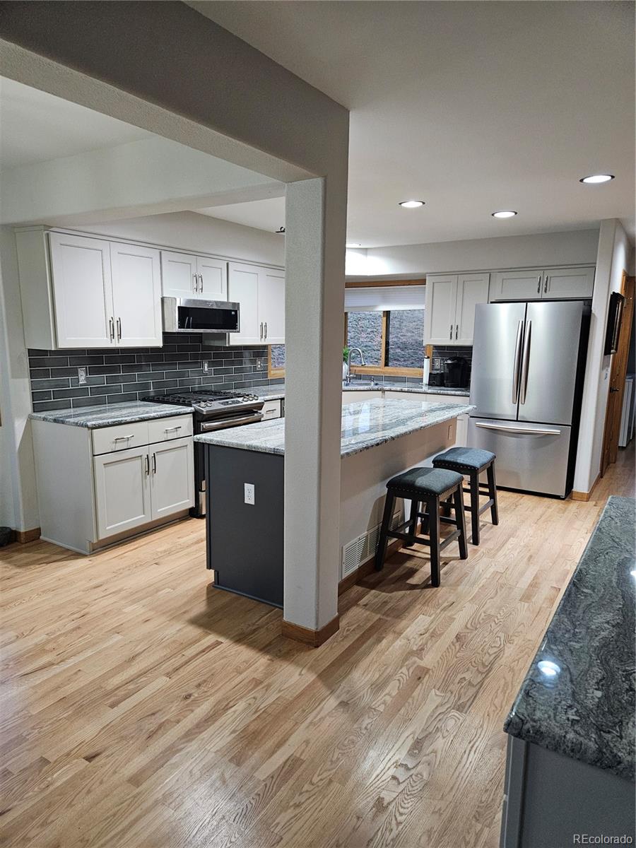 386 Monte Vista Road Golden, CO 80401 - Photo 9 of 32 a kitchen with stainless steel appliances granite countertop a refrigerator and a stove top oven