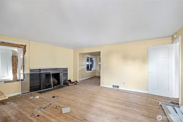an empty room with fireplace and windows