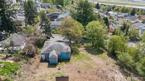 an aerial view of a house with a yard and large tree