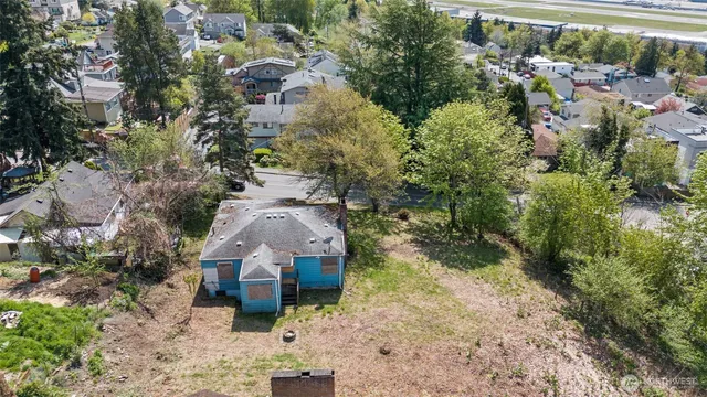 an aerial view of a house with a yard and large tree
