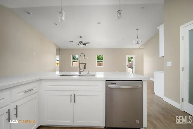 a kitchen with white cabinets and sink