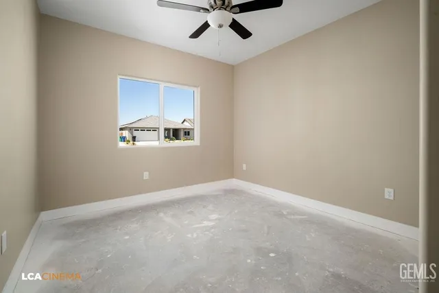 an empty room with a window and a ceiling fan