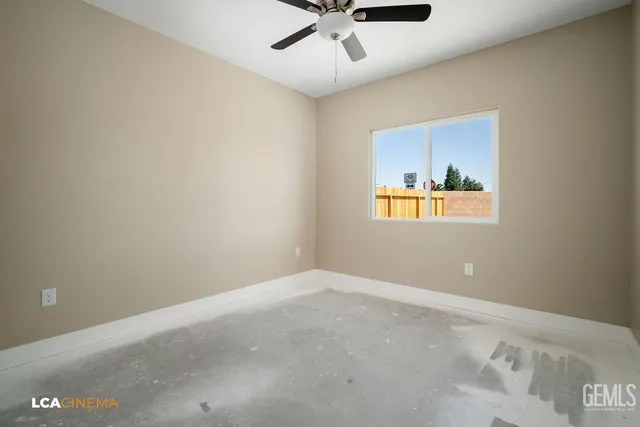 an empty room with a window and a fan