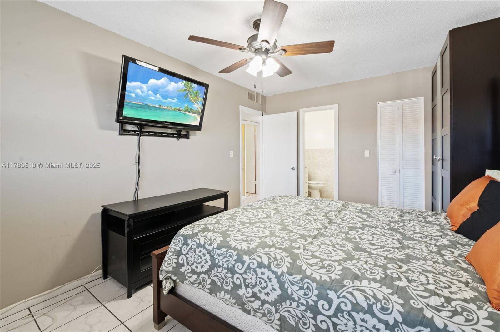 5300 Washington Street, Unit G323 Hollywood, FL 33021 - Photo 18 of 34 a bedroom with a bed and a flat screen tv