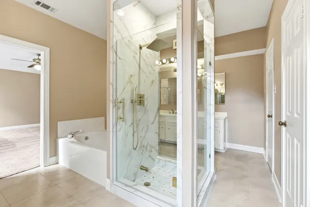a spacious bathroom with a tub shower and sink