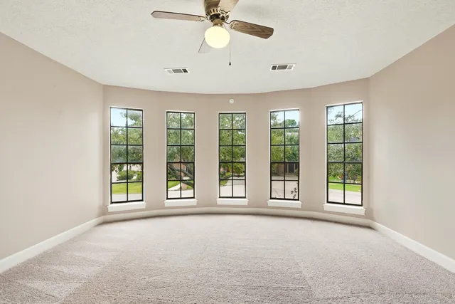 wooden floor in an empty room with a ceiling fan