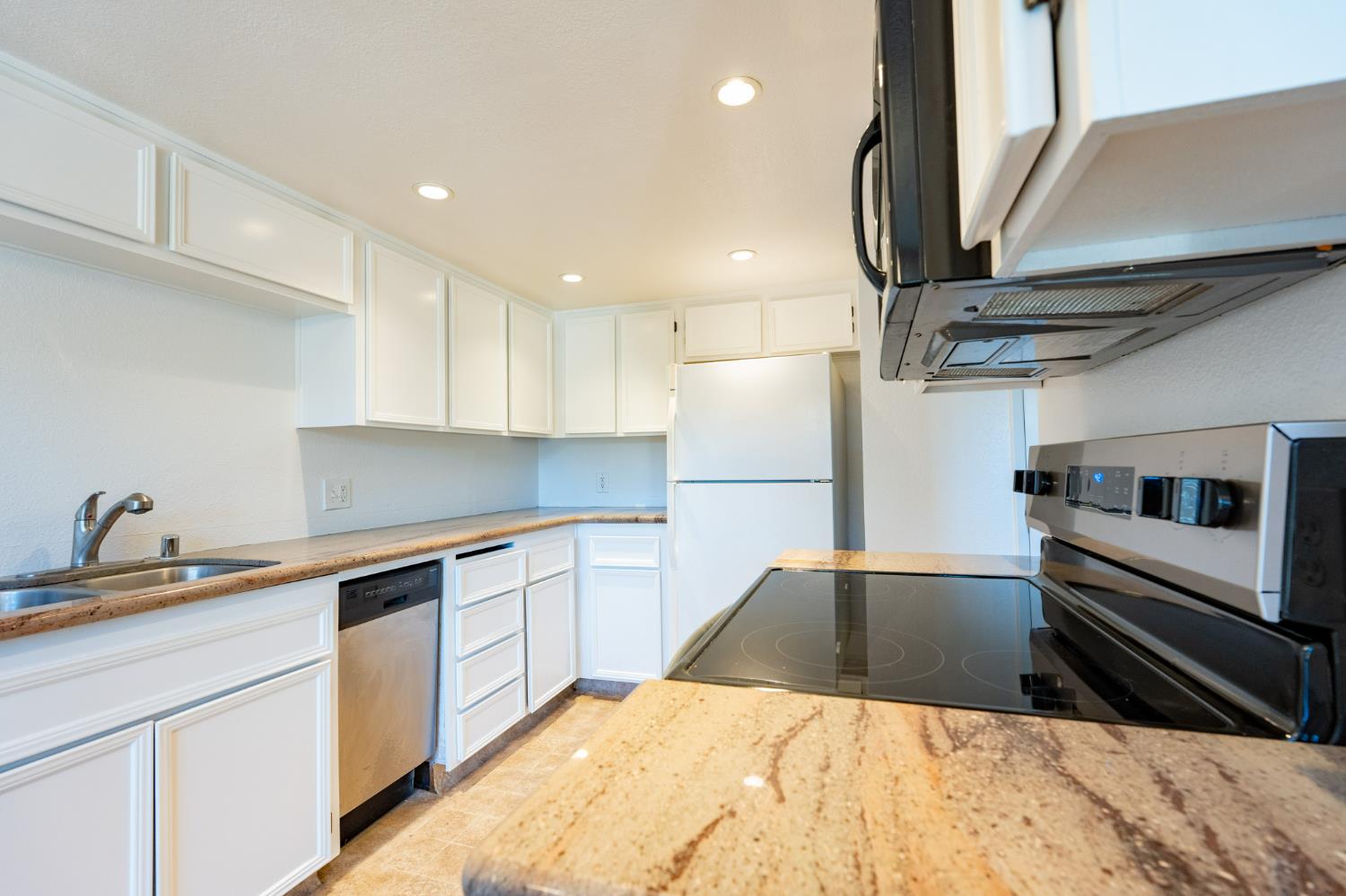 3701 Colonial Drive, Unit 89 Modesto, CA 95356 - Photo 4 of 20 a kitchen with a sink a refrigerator and cabinets
