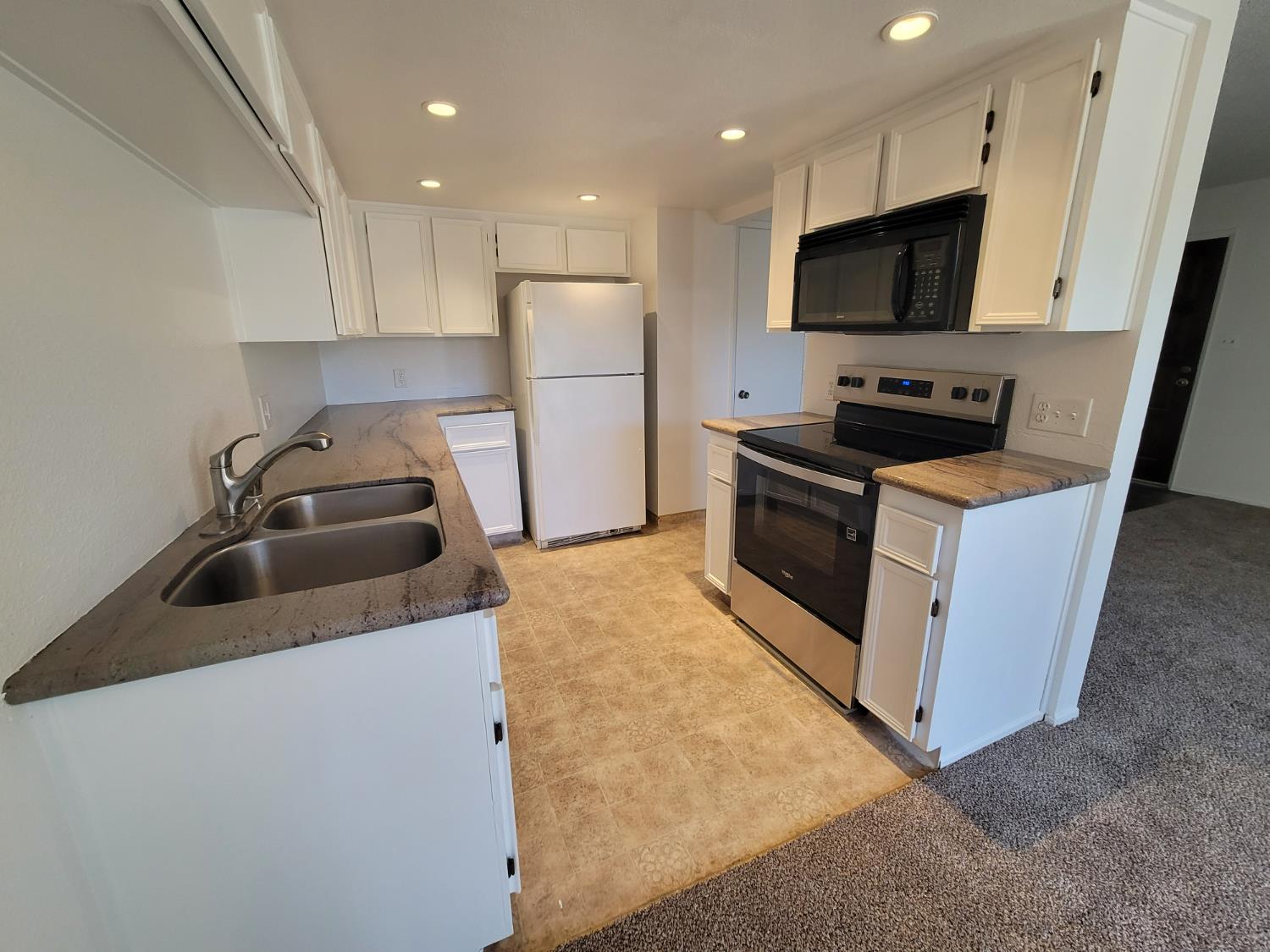 3701 Colonial Drive, Unit 89 Modesto, CA 95356 - Photo 5 of 20 a kitchen with stainless steel appliances a stove a sink a microwave a refrigerator a refrigerator and cabinets