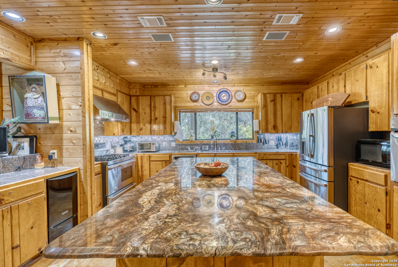 4983 Ranch Road 1051 Uvalde, TX 78801 - Photo 17 of 72 a large kitchen with stainless steel appliances kitchen island granite countertop a refrigerator and a stove