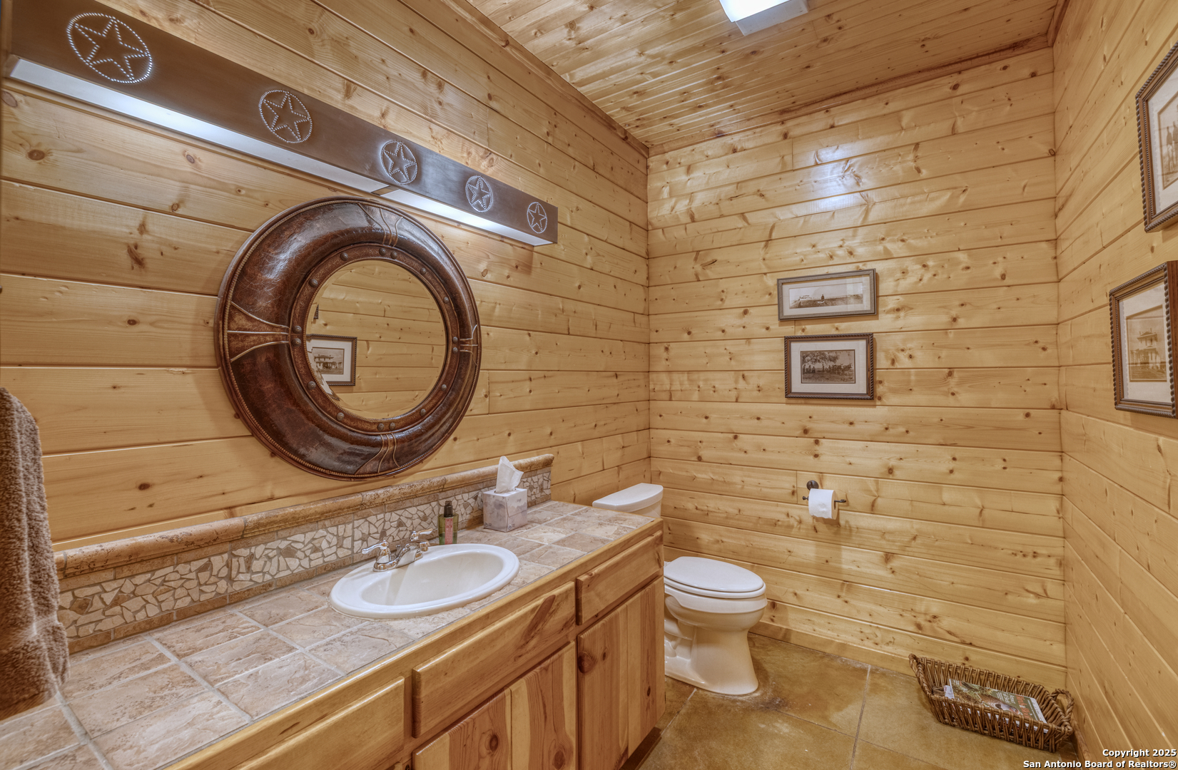 4983 Ranch Road 1051 Uvalde, TX 78801 - Photo 29 of 72 a bathroom with a granite countertop toilet a sink and a mirror