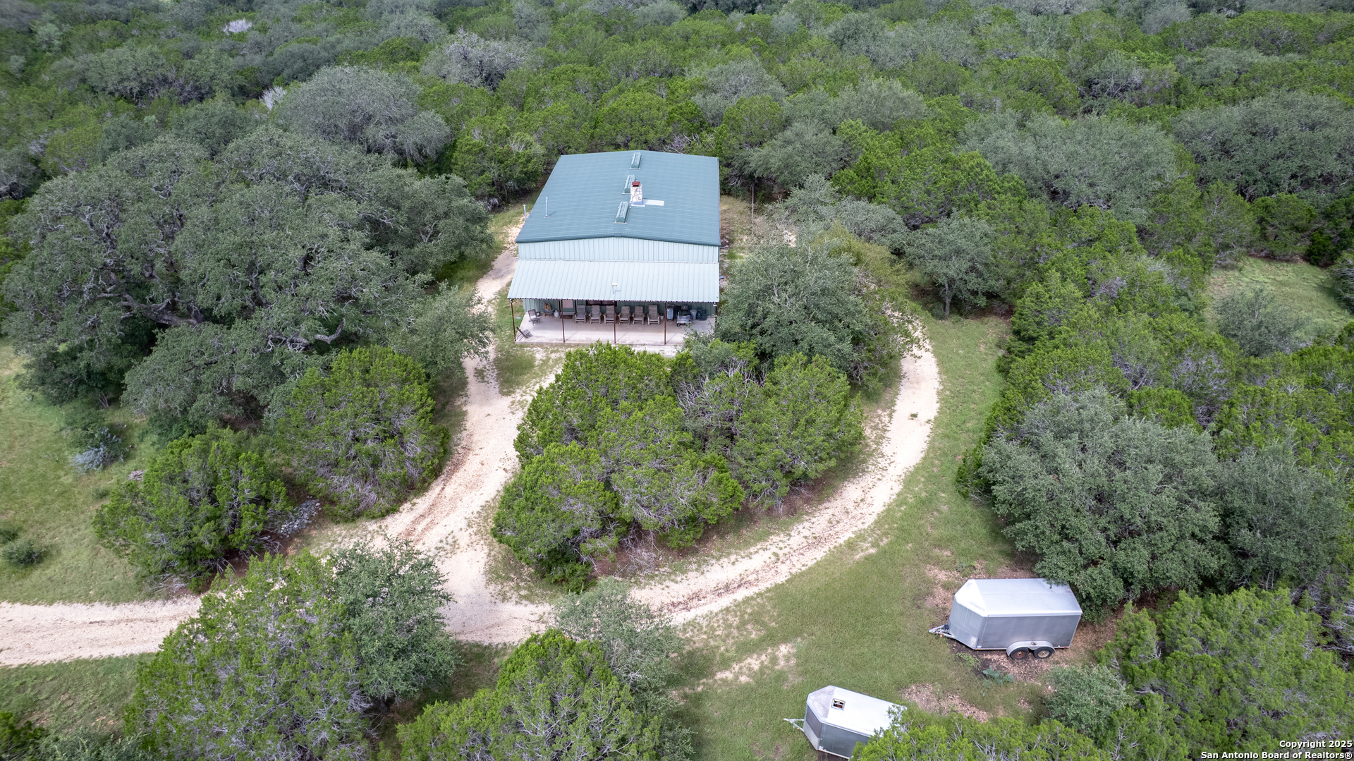 4983 Ranch Road 1051 Uvalde, TX 78801 - Photo 66 of 72 an aerial view of a house with a yard and trees all around