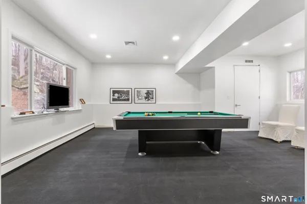 a room with furniture pool table and flat screen tv