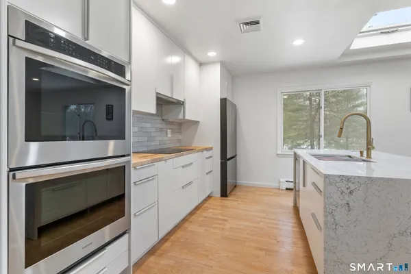 a kitchen with stainless steel appliances granite countertop a sink stove and refrigerator