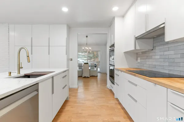 a kitchen with kitchen island granite countertop a sink stove and cabinets