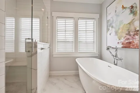 a white bath tub sitting in a bathroom next to a window