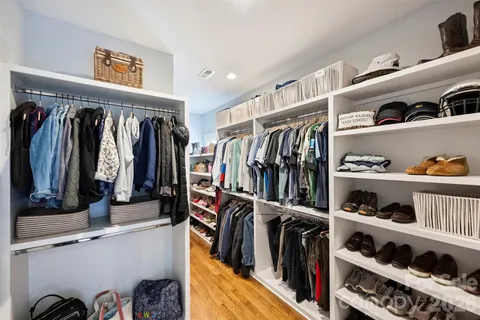 a view of walk in closet with clothes and shoes