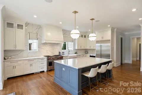 a large kitchen with stainless steel appliances granite countertop a stove a sink a center island a table and chairs